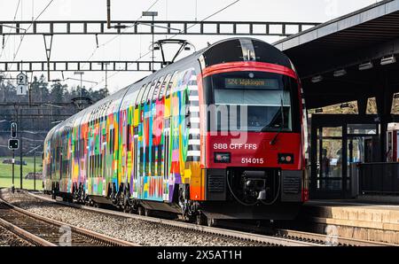 Eine Zürcher S-Bahn der Linie S24 (S-Bahn 24) vom Typ SBB Rabe 514 steht im Bahnhof Bassersdorf. Der Zug trägt die ZVV-Werbung mit dem Titel 'Gemeinsa Stockfoto