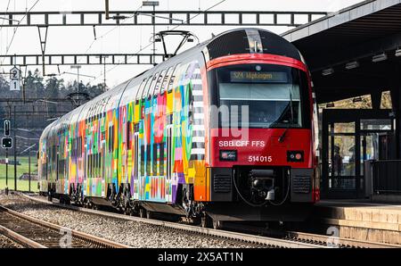 Eine Zürcher S-Bahn der Linie S24 (S-Bahn 24) vom Typ SBB Rabe 514 steht im Bahnhof Bassersdorf. Der Zug trägt die ZVV-Werbung mit dem Titel 'Gemeinsa Stockfoto