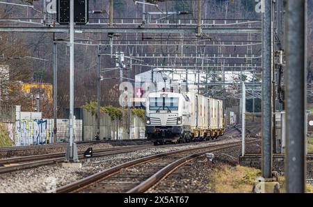 Eine Vectron AC der Logistikfirma railCare zieht Güterwagen des Lebensmitteldetailhändlers Coop und fährt durch den Bahnhof von Bassersdorf im Zürcher Stockfoto