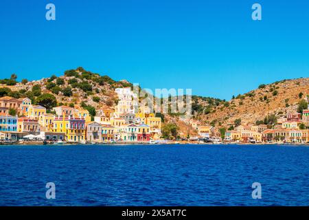 SYMI, Griechenland - 03. JUNI 2021. Der Hafen von Symi Stadt mit den Bezirken Chorio und Gialos ist einer der schönsten und romantischsten in der ganzen A Stockfoto