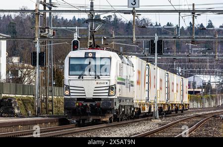 Eine Vectron AC der Logistikfirma railCare zieht Güterwagen des Lebensmitteldetailhändlers Coop und fährt durch den Bahnhof von Bassersdorf im Zürcher Stockfoto