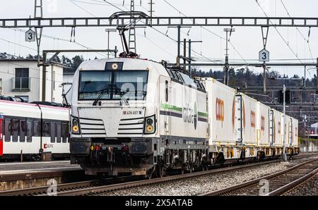 Eine Vectron AC der Logistikfirma railCare zieht Güterwagen des Lebensmitteldetailhändlers Coop und fährt durch den Bahnhof von Bassersdorf im Zürcher Stockfoto