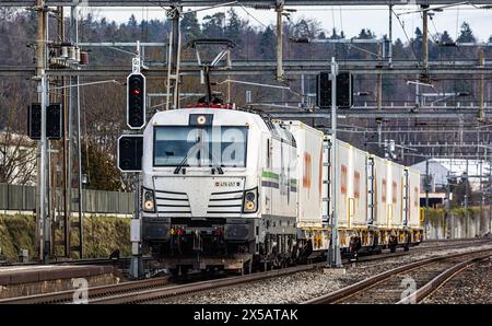 Eine Vectron AC der Logistikfirma railCare zieht Güterwagen des Lebensmitteldetailhändlers Coop und fährt durch den Bahnhof von Bassersdorf im Zürcher Stockfoto