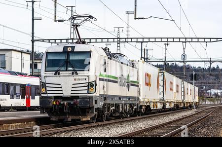 Eine Vectron AC der Logistikfirma railCare zieht Güterwagen des Lebensmitteldetailhändlers Coop und fährt durch den Bahnhof von Bassersdorf im Zürcher Stockfoto