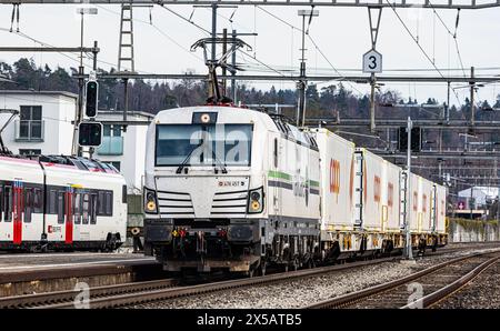 Eine Vectron AC der Logistikfirma railCare zieht Güterwagen des Lebensmitteldetailhändlers Coop und fährt durch den Bahnhof von Bassersdorf im Zürcher Stockfoto