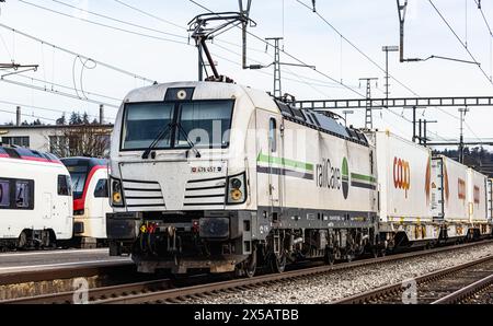 Eine Vectron AC der Logistikfirma railCare zieht Güterwagen des Lebensmitteldetailhändlers Coop und fährt durch den Bahnhof von Bassersdorf im Zürcher Stockfoto