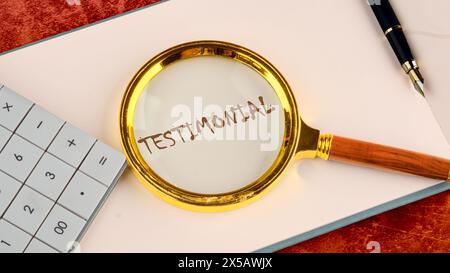 TESTIMONIAL im Geschäftsbuch des Kopfes mit einer Lupe oben neben dem Rechner und einem Stift in der Komposition Stockfoto