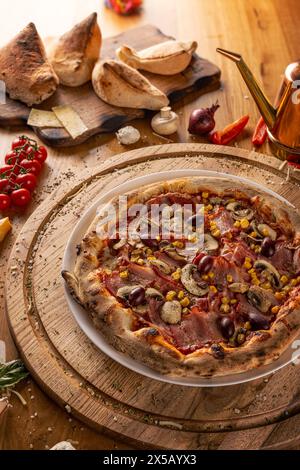 Pizza Capriciosa auf einem Teller nah oben auf dem Tisch Stockfoto