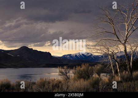 Sturmwolken ziehen über das Little Wood River Reservoir, während das Sonnenuntergangslicht durch die Wolken bricht. Bureau of Reclamation, Idaho Stockfoto