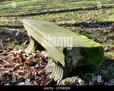 Granitbank im Schlosspark Putbus: Historischer Charme, moosbedeckt, in der Nähe des Mausoleums der Familie Putbus, strahlt Ruhe und Besinnung aus. Stockfoto