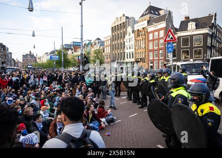 AMSTERDAM - Polizeibeamte versuchen, die Demonstranten auf dem Rokin zu stoppen. Am Morgen sind die von Demonstranten auf dem Binnengasthuis-Gelände der Universität Amsterdam (UVA) errichteten Barrikaden noch sichtbar. Die Eingänge zum Standort sind von mehreren Seiten blockiert, unter anderem mit Paletten und Fahrradständern. ANP RAMON VAN FLYMEN niederlande aus - belgien aus Stockfoto