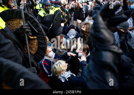 AMSTERDAM - Polizeibeamte versuchen, die Demonstranten auf dem Rokin zu stoppen. Am Morgen sind die von Demonstranten auf dem Binnengasthuis-Gelände der Universität Amsterdam (UVA) errichteten Barrikaden noch sichtbar. Die Eingänge zum Standort sind von mehreren Seiten blockiert, unter anderem mit Paletten und Fahrradständern. ANP RAMON VAN FLYMEN niederlande aus - belgien aus Stockfoto