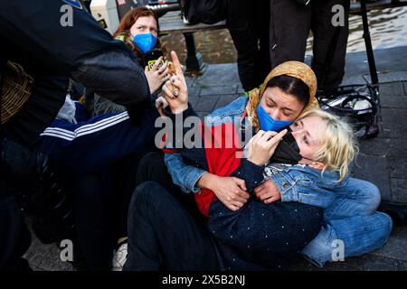 AMSTERDAM - Polizeibeamte versuchen, die Demonstranten auf dem Rokin zu stoppen. Am Morgen sind die von Demonstranten auf dem Binnengasthuis-Gelände der Universität Amsterdam (UVA) errichteten Barrikaden noch sichtbar. Die Eingänge zum Standort sind von mehreren Seiten blockiert, unter anderem mit Paletten und Fahrradständern. ANP RAMON VAN FLYMEN niederlande aus - belgien aus Stockfoto