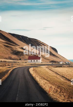 Wunderschöne Herbstlandschaft der lutherischen Kirche Reynisfjara mit der Straße zum Strand Reynisfjara in Vik, Island Stockfoto