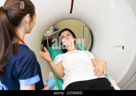 CT-Scan-MTRA überblickt Patienten im Computer-Tomographie-Scanner während der Vorbereitung des Verfahrens. Patientin, die in den CT-Scanner geht. Stockfoto