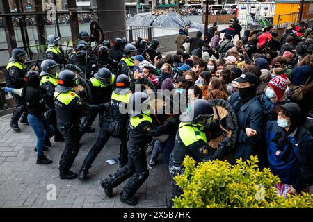 AMSTERDAM: Polizeibeamte versuchen, Demonstranten auf dem Rokin aufzuhalten. Am Morgen sind die von Demonstranten auf dem Binnengasthuis-Gelände der Universität Amsterdam (UVA) errichteten Barrikaden noch sichtbar. Die Eingänge zum Standort sind von mehreren Seiten blockiert, unter anderem mit Paletten und Fahrradständern. ANP RAMON VAN FLYMEN niederlande aus - belgien aus Stockfoto