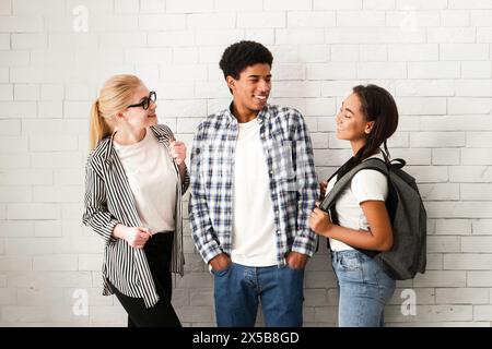 Eine Gruppe von Teenagern steht vor der weißen Ziegelmauer Stockfoto