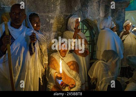 Teilnehmer wurden während der Prozession der Heiligen Feuerzeremonie der Äthiopisch-orthodoxen Kirche in Jerusalem gesehen. Die Heilige Feuerzeremonie wird jedes Jahr vor Ostern von orthodoxen Kirchen in der Grabeskirche in Jerusalem gefeiert. Dieses spirituelle und religiöse Ereignis ist eines der wichtigsten Rituale des orthodoxen Christentums, und viele Pilger kommen aus der ganzen Welt, um es zu bezeugen. Während der Zeremonie betet der griechische Patriarch in die Ädikulae, wo sich das Grab Jesu befindet, und betet, bis das heilige Feuer vom Heiligen Geist angezündet wird. Die Menschenmassen in der Kirche W Stockfoto