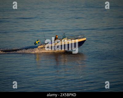 Motorboot bei Sonnenuntergang vor Klåva, Hönö, dem Archipel von Göteborg, Schweden. Stockfoto