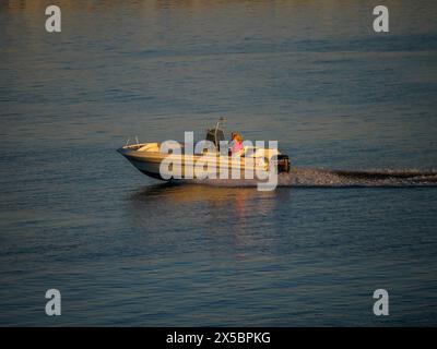 Motorboot bei Sonnenuntergang vor Klåva, Hönö, dem Archipel von Göteborg, Schweden. Stockfoto