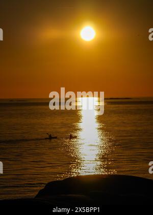 Zwei Personen Kajak in den Sonnenuntergang außerhalb Klåva, Hönö, der Schären von Göteborg, Schweden. Stockfoto