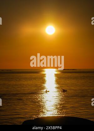 Zwei Personen Kajak in den Sonnenuntergang außerhalb Klåva, Hönö, der Schären von Göteborg, Schweden. Stockfoto