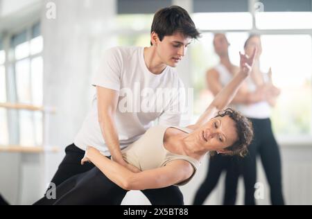 Anmutige Balletttänzer, die in der Gruppenklasse Unterstützung geben Stockfoto