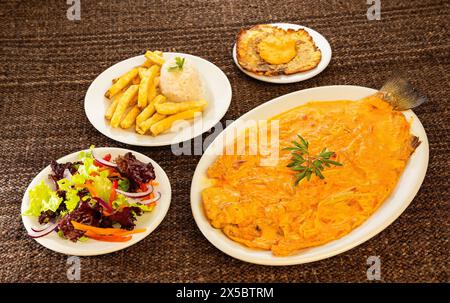 Regenbogenforelle vom Tota Boyaca See - gebackenes Forellenfilet mit Zwiebeln. Kolumbianische Gastronomie Stockfoto