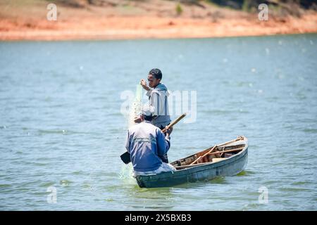 Montasoa, Madagaskar 08.10.2023. Zwei Fischer in einem kleinen Boot auf dem See werfen ein Netz, um Fische zu fangen Stockfoto