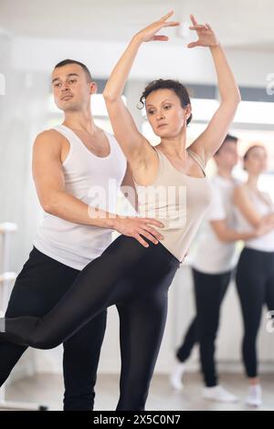 Anmutige Balletttänzer, die in der Gruppenklasse Unterstützung geben Stockfoto