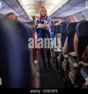 Ein Flugbegleiter serviert Getränke in einem Flugzeug in den Vereinigten Staaten. Stockfoto