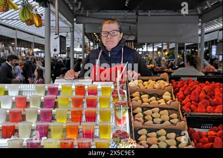 Verkäufer mit farbenfroher Präsentation von Fruchtgetränken auf dem zentralen Markt in Porto, Portugal, Europa Stockfoto