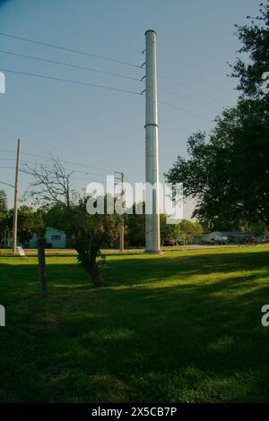 Vertikale Ansicht bei Sonnenuntergang der elektrischen Umspannstation mit Hochspannungsleitungen in St. Petersburg, Florida. Nutzfahrzeuge. Blick auf grünes Gras und blauer Himmel. Stockfoto