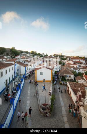 Óbidos, Portugal. Blick nach Norden über den Padrao Camoniano Platz vom Porta da Vila (doppelwandiges Südtor). Die Straße links ist Rua Direita und Rua Josefa de Obidos auf der rechten Seite. Die mittelalterliche Stadt, die seit 308 v. Chr. bewohnt wurde, ist eine der am besten erhaltenen klassischen Mauersiedlungen Portugals mit einer heutigen Bevölkerung von über 3.000 Einwohnern, 100 km nördlich der portugiesischen Hauptstadt Lissabon an der Atlantikküste. Stockfoto