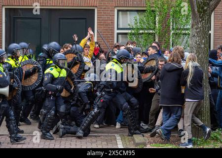 Amsterdam, Niederlande. Mai 2024. Polizei mit Schlagstöcken und Schilden stößt Demonstranten zurück. Die Polizei demontiert einen propalästinensischen Studentenprotest und eine Besatzung an der Universität Amsterdam mit Schlagstöcken, Schilden und Erdbewegungsgeräten. Die Konfrontation folgte, als die Demonstranten sich unter Spannungen für die palästinensische Solidarität versammelten, intervenierten die Strafverfolgungsbehörden, um die Menge zu zerstreuen, was zu Zusammenstößen und Festnahmen führte. (Foto: Michael Currie/SOPA Images/SIPA USA) Credit: SIPA USA/Alamy Live News Stockfoto