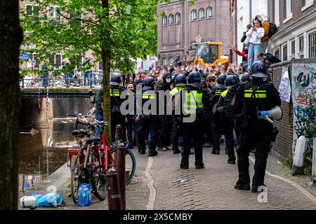 Eine Gruppe von Unterstützern hält die Hände hoch und bittet die Polizei, sie gehen zu lassen, nachdem die Polizei Barrikaden durchbrach, um eine propalästinensische Studentenbesetzung an der Universität Amsterdam zu beenden. Die Polizei demontiert einen propalästinensischen Studentenprotest und eine Besatzung an der Universität Amsterdam mit Schlagstöcken, Schilden und Erdbewegungsgeräten. Die Konfrontation folgte, als die Demonstranten sich unter Spannungen für die palästinensische Solidarität versammelten, intervenierten die Strafverfolgungsbehörden, um die Menge zu zerstreuen, was zu Zusammenstößen und Festnahmen führte. (Foto: Michael Currie/SOPA Images/SIPA USA) Stockfoto