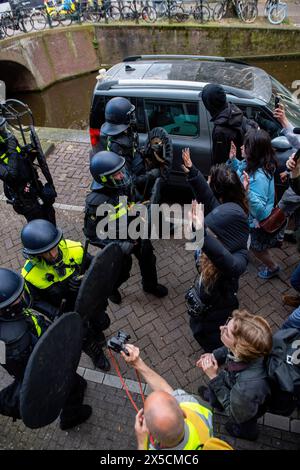 Polizei mit Schlagstöcken und Schilden kontrolliert Studenten, nachdem sie Barrikaden durchbrach, um eine propalästinensische Studentenbesetzung an der Universität Amsterdam zu beenden. Die Polizei demontiert einen propalästinensischen Studentenprotest und eine Besatzung an der Universität Amsterdam mit Schlagstöcken, Schilden und Erdbewegungsgeräten. Die Konfrontation folgte, als die Demonstranten sich unter Spannungen für die palästinensische Solidarität versammelten, intervenierten die Strafverfolgungsbehörden, um die Menge zu zerstreuen, was zu Zusammenstößen und Festnahmen führte. (Foto: Michael Currie/SOPA Images/SIPA USA) Stockfoto