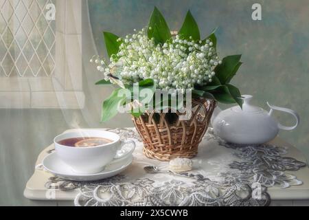 Stillleben mit Blumenstrauß Maiglöckchen auf einem Teetisch Stockfoto