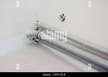 Schließen Sie nach dem Verputzen pvc-Rohre in der im Bau befindlichen Ecke der Küchenwand. Stockfoto