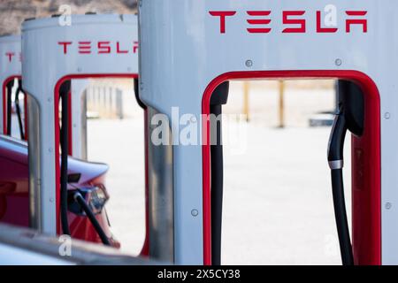 Eine große Sammlung von Tesla Superchargern in Aktion entlang der Interstate 15 in Baker, Kalifornien, USA. Das Netz der Kompressoren bildet das Rückgrat von Tesla“ Stockfoto