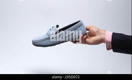 Hellblaue Leder-Loafer zum Hineinschlüpfen in der Hand Stockfoto