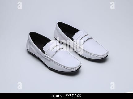 Weiße Leder-Loafers Slip-on-Schuhe isoliert auf grauem Hintergrund Stockfoto