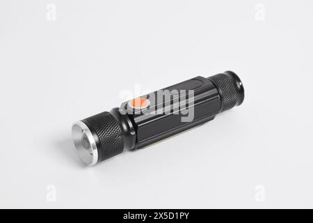 Moderne Metall-LED-Taschenlampe in schwarzer Farbe isoliert auf weißem Hintergrund. Tragbare Taschenlampe, LED-Campinglampe Stockfoto