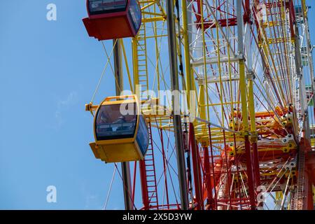 Riesenrad Über Dem Blauen Himmel. Bunte Kabinen eines Riesenrads über einem blauen Himmel. Karussell. Buntes Riesenrad am blauen Himmel. Stockfoto