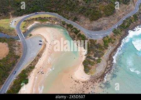 Aus der Vogelperspektive einer Straße, die sich um eine dramatische Küste und Flussmündung bei Lorne an der Great Ocean Road in Victoria, Australien, windet. Stockfoto