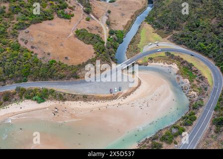 Aus der Vogelperspektive einer Straße, die sich um eine dramatische Küste und Flussmündung bei Lorne an der Great Ocean Road in Victoria, Australien, windet. Stockfoto