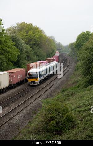 Chiltern Railways Class 165 Diesel, der einen freightliner-Zug in Hatton Down Loop Line, Warwickshire, UK, überquert Stockfoto