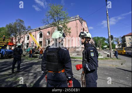 Nicht exklusiv: ZAPORIZHZHIA, UKRAINE - 8. MAI 2024 - Retter werden außerhalb des Kulturpalastes gesehen, der durch die nächtliche massive Ru beschädigt wurde Stockfoto