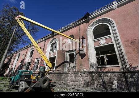 Nicht exklusiv: ZAPORIZHZHIA, UKRAINE - 8. MAI 2024 - Stadtarbeiter werden vor dem Kulturpalast gesehen, der durch die nächtliche Nacht beschädigt wurde Stockfoto