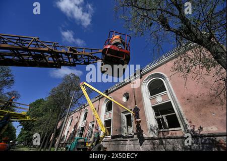 Nicht exklusiv: ZAPORIZHZHIA, UKRAINE - 8. MAI 2024 - Stadtarbeiter werden vor dem Kulturpalast gesehen, der durch die nächtliche Nacht beschädigt wurde Stockfoto